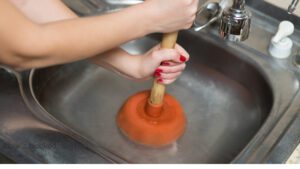 Unblocking a sink with a plunger